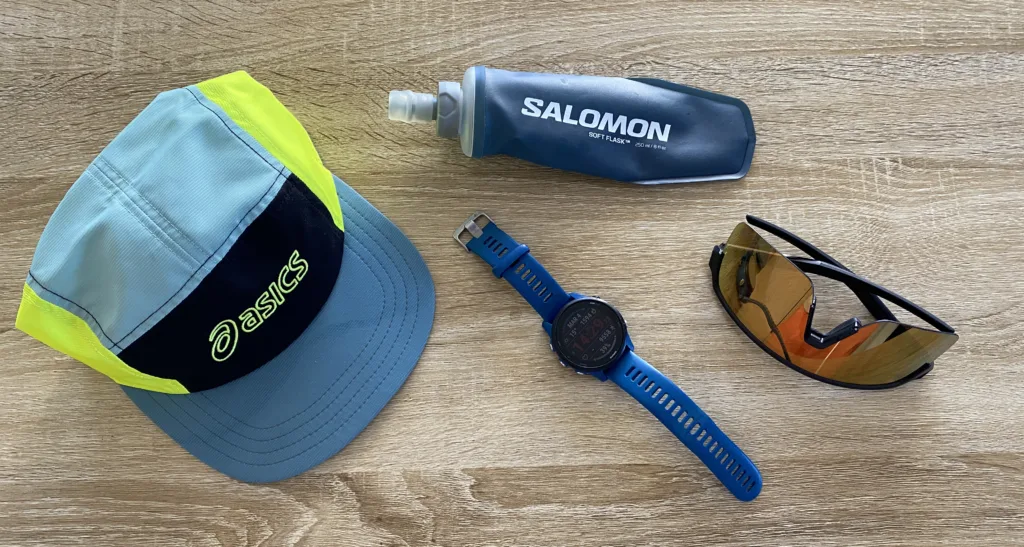 Exemple de matériel pour la course à pied : casquette, lunette, flasque d'eau, montre connectée. A ça peut se rajouter des écouteurs ou une frontale par exemple